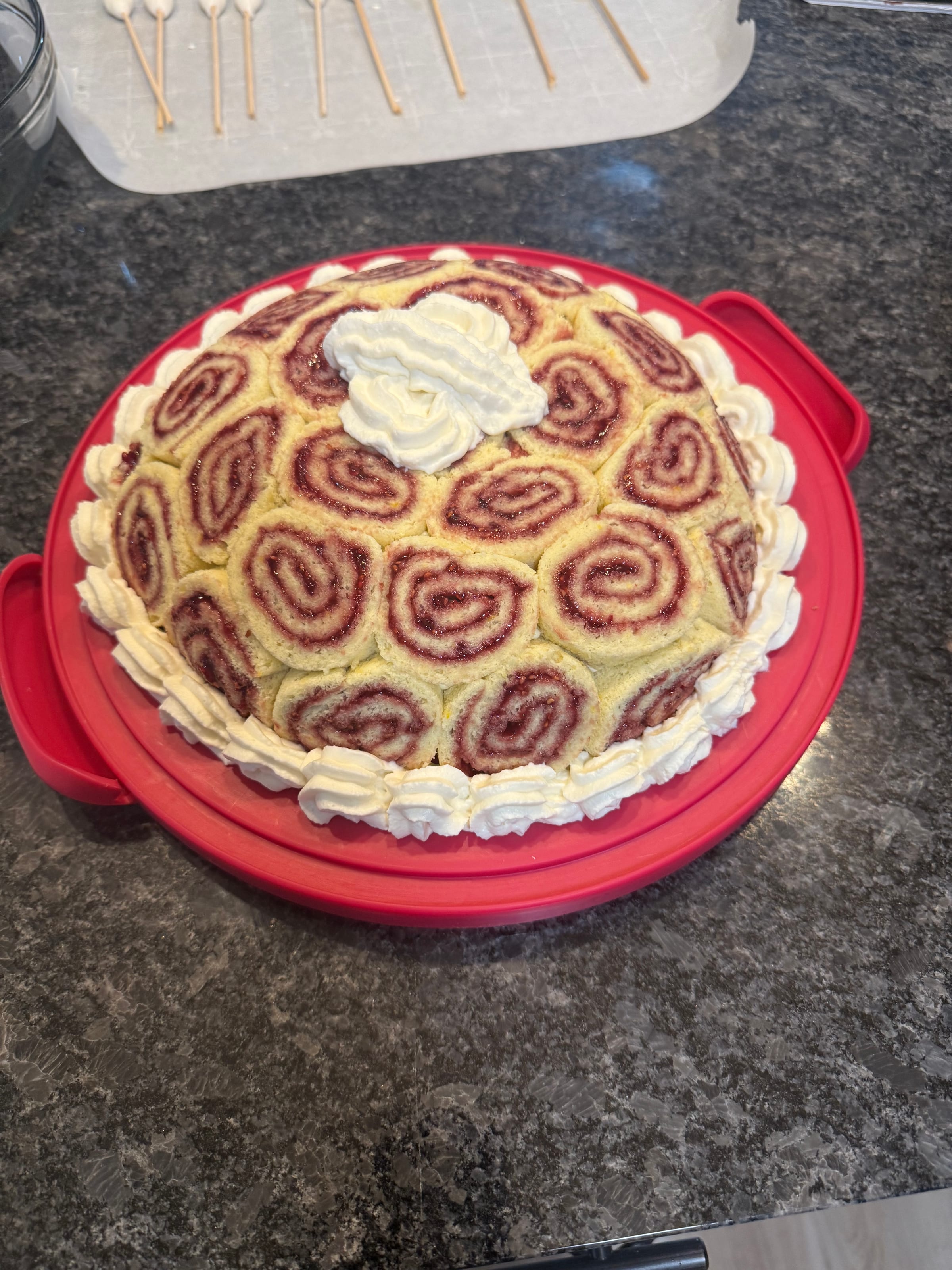 Swiss roll cake with whipped cream piped around the border